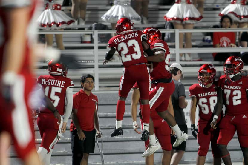 Woodrow Wilson running back Keitron Pearson (23) skies with a teammate in celebration of his...