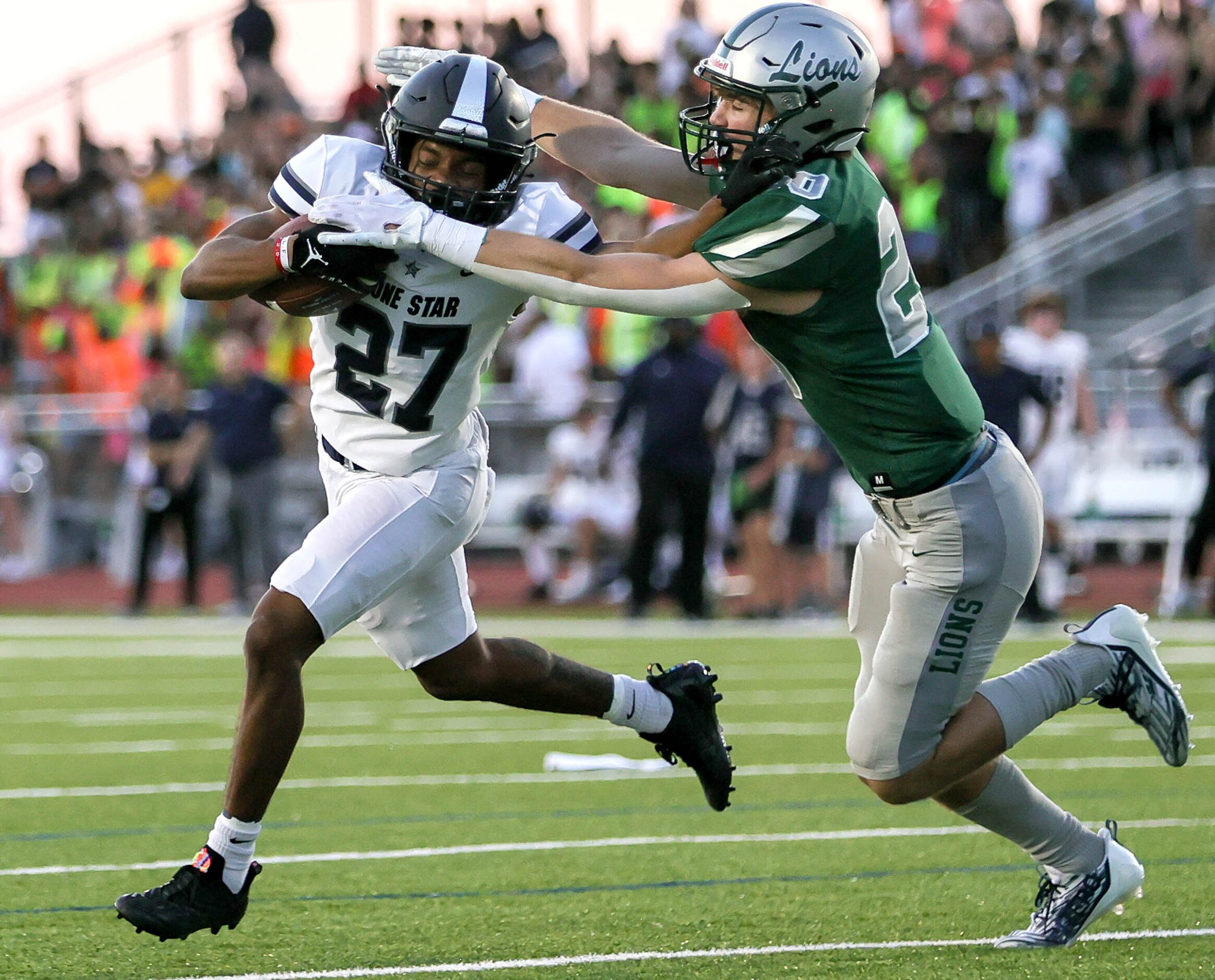 Frisco Lone Star running back Javon Hubbard (27) tries to fight off a tackle from Frisco...