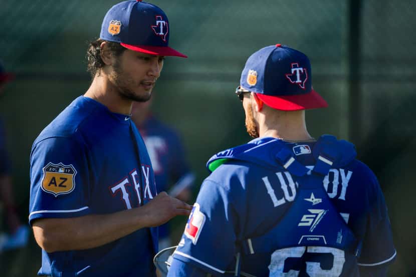 Texas Rangers starting pitcher Yu Darvish (11) talks to catcher Jonathan Lucroy (25) during...