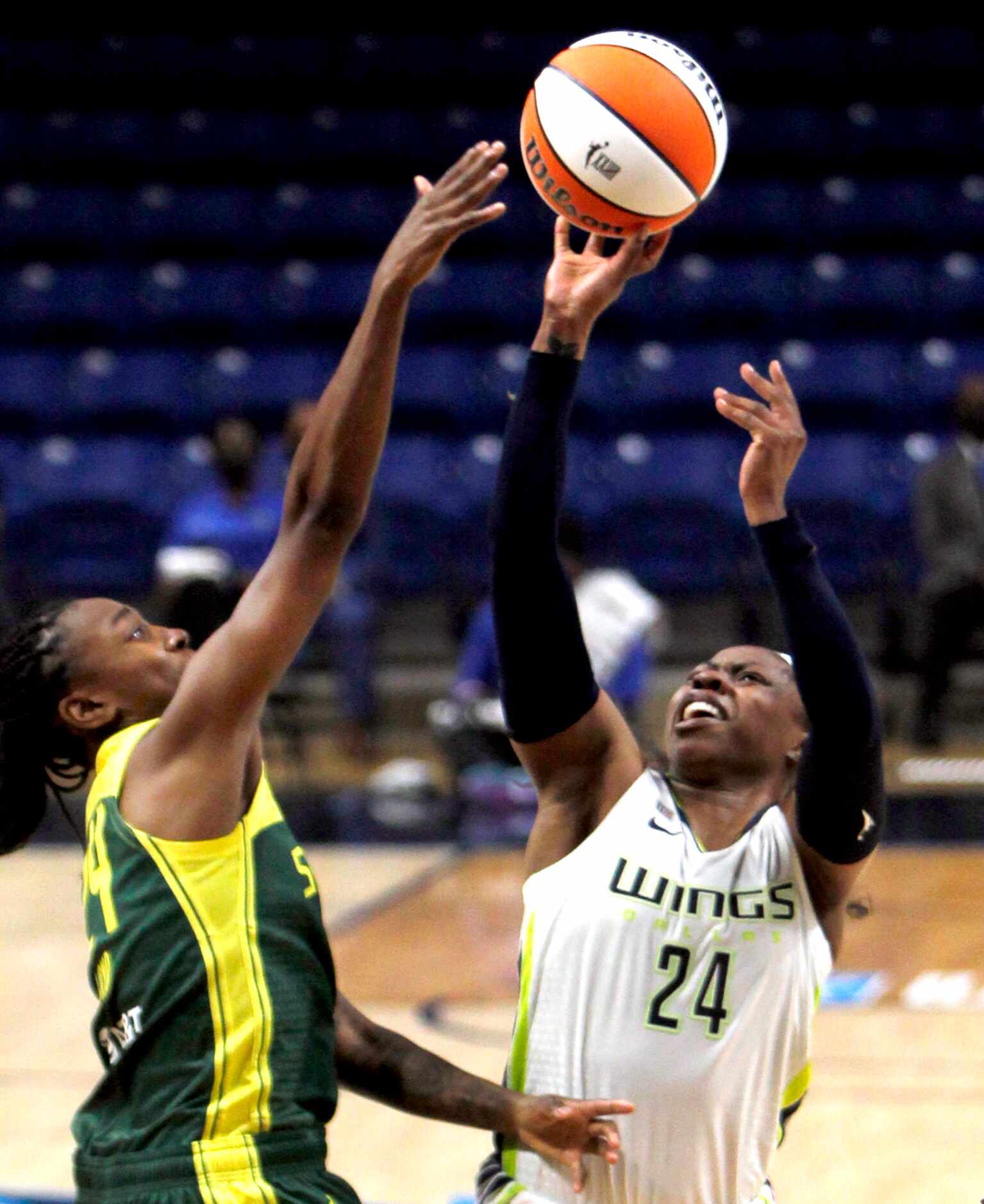 Dallas Wings guard Arike Ogunbowale (24) puts up a shot against the tight defense of Seattle...
