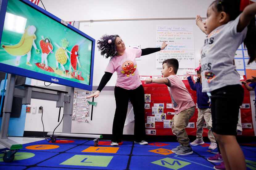 Pre-K teacher Patricia Sifuentes (left) leads a music and movement video lesson for her...