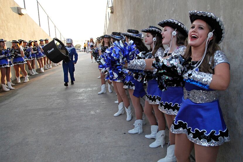 Angel Allen (right), 16, with the Plano West Royales drill team, cheers the band taking thge...