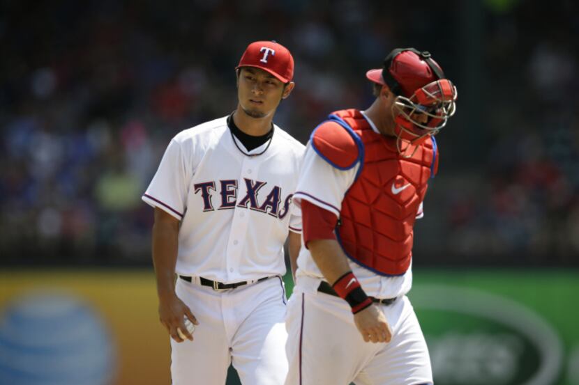 Texas Rangers' Yu Darvish (11) of Japan gets a visit on the mound from catcher A.J....