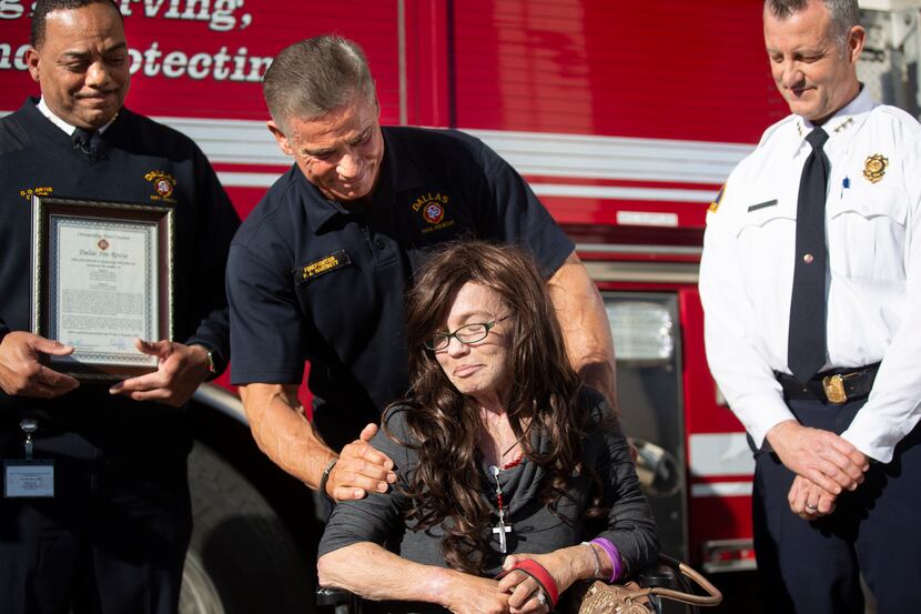 Dallas Fire-Rescue firefighter Peter Hartnett and Danyeil Townzen share a moment during a...