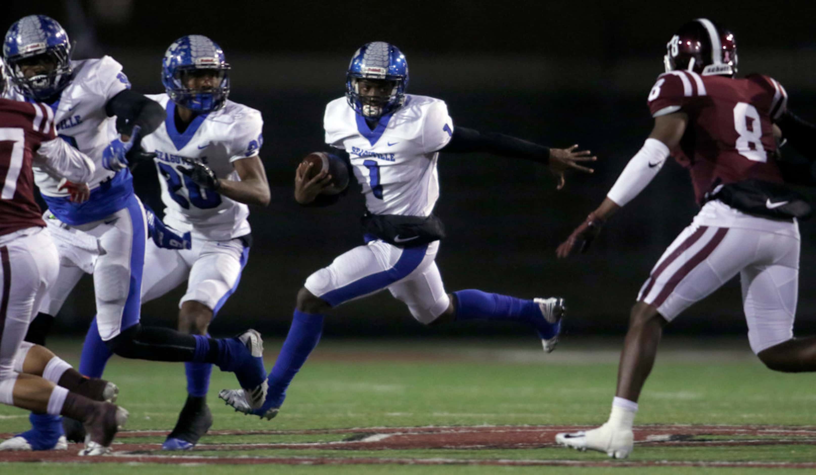 Seagoville quarterback Eric Hall Jr. (1) follows his blockers as he eyes the approaching...