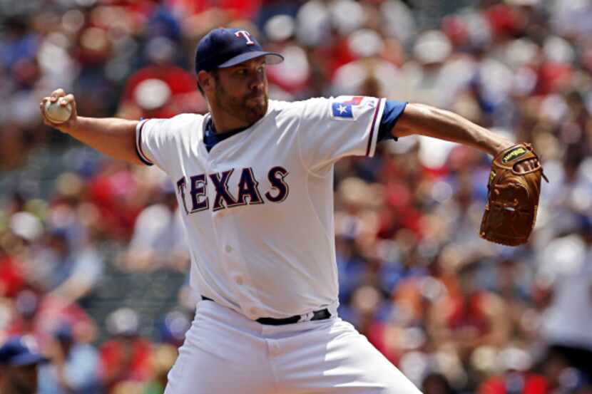 Texas Rangers starting pitcher Colby Lewis throws during the first inning of Texas' 11-7...