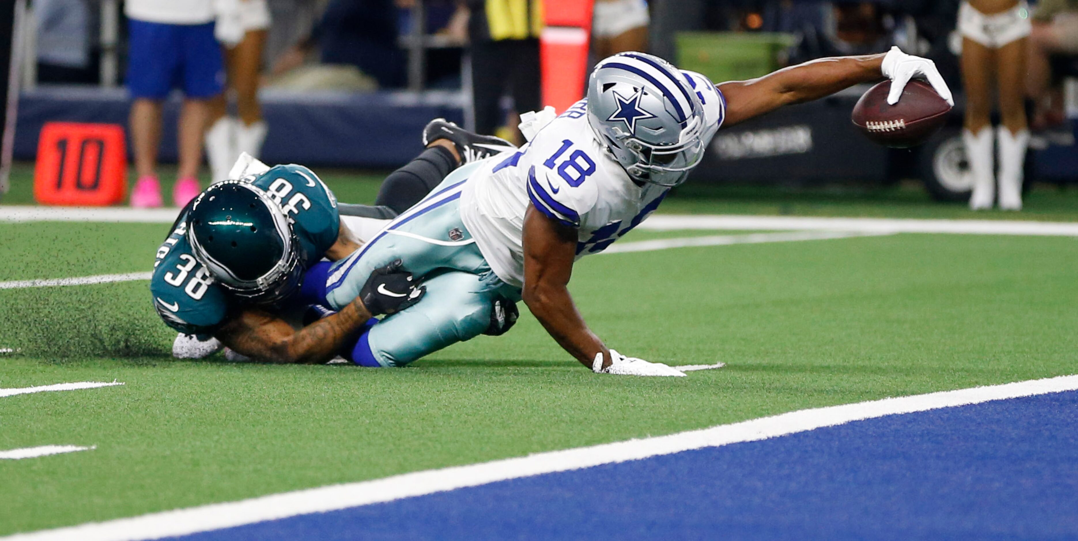 Dallas Cowboys wide receiver Randall Cobb (18) stretches for more yards as he is tackled by...