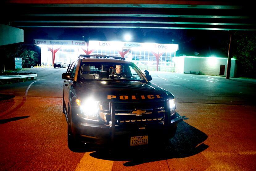 Officer Stephen Burres III watches for drunken drivers near a liquor store on Northwest...