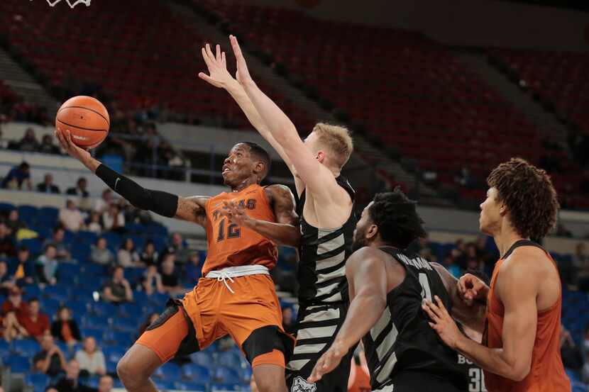 Texas' Kerwin Roach (12) gets to the basket past a Butler defender in the second half of an...