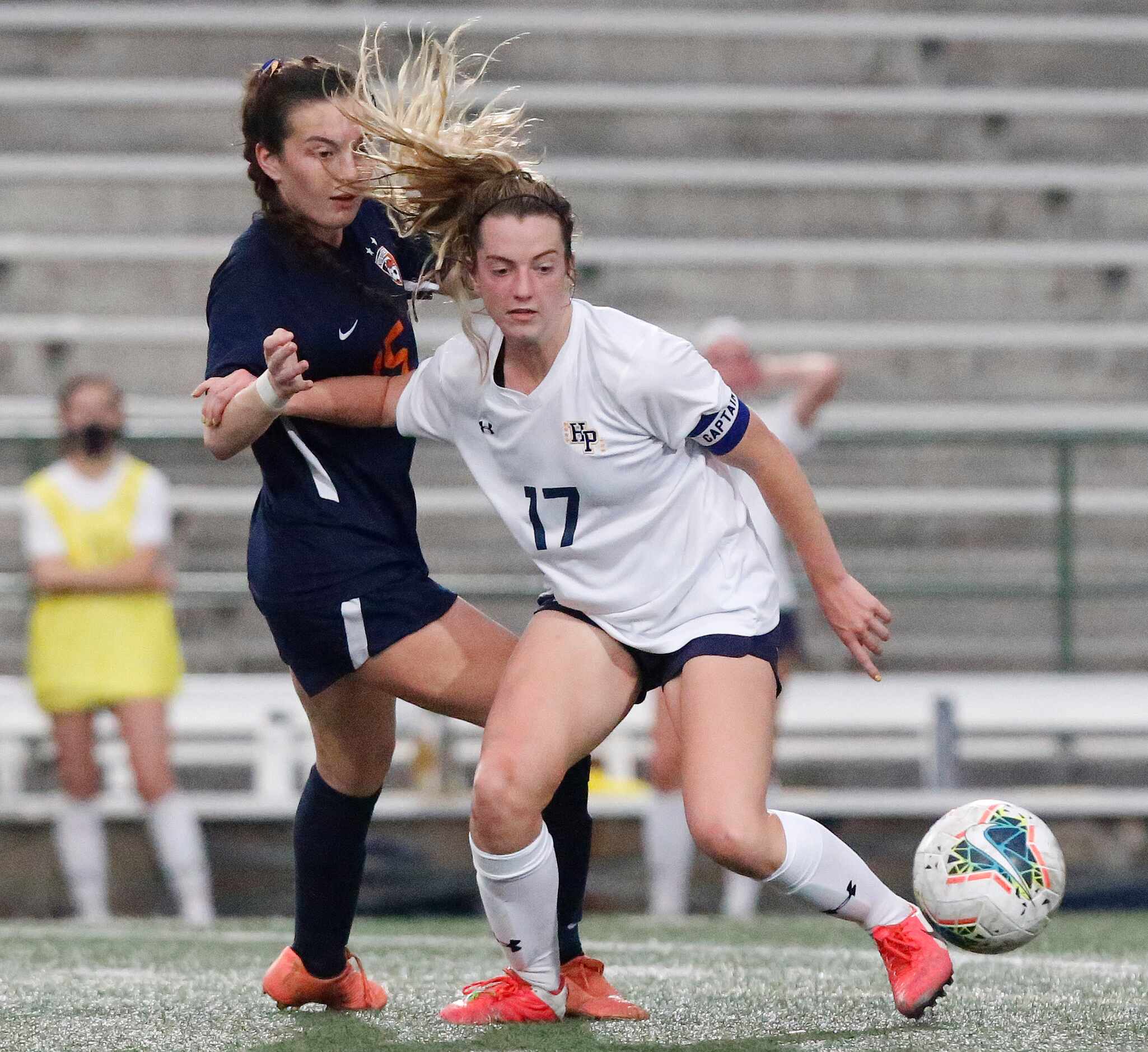 Highland Park defender Maddie McNeely (17) sheilds Wakeland midfielder Allie Perry from the...