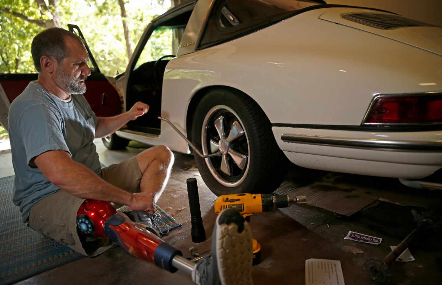 Michael Orlie works on his 1967 Porsche as he poses for a photograph at his home in...