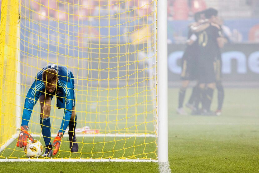 Toronto FC goalkeeper Clint Irwin picks the ball out of the net after Los Angeles FC's...