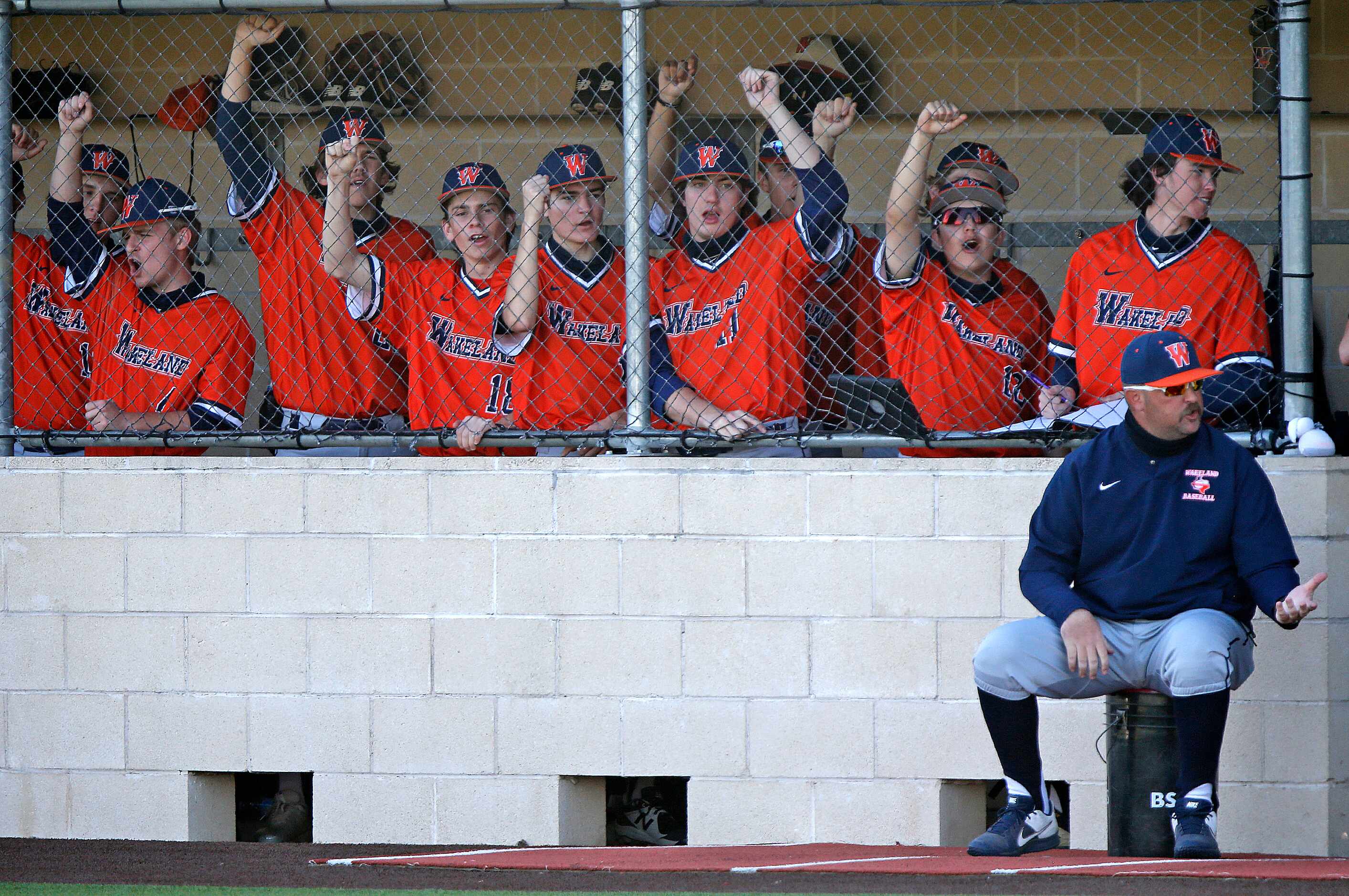 The Wakeland dugout cheers during the fifth inning as Heritage High School hosted Wakeland...