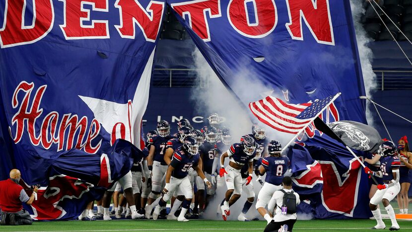 The Denton Ryan football team enters the field before the first half of the Class 5A...