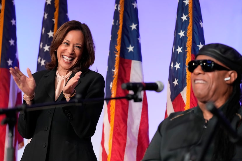 Democratic presidential nominee Vice President Kamala Harris listens as Stevie Wonder...