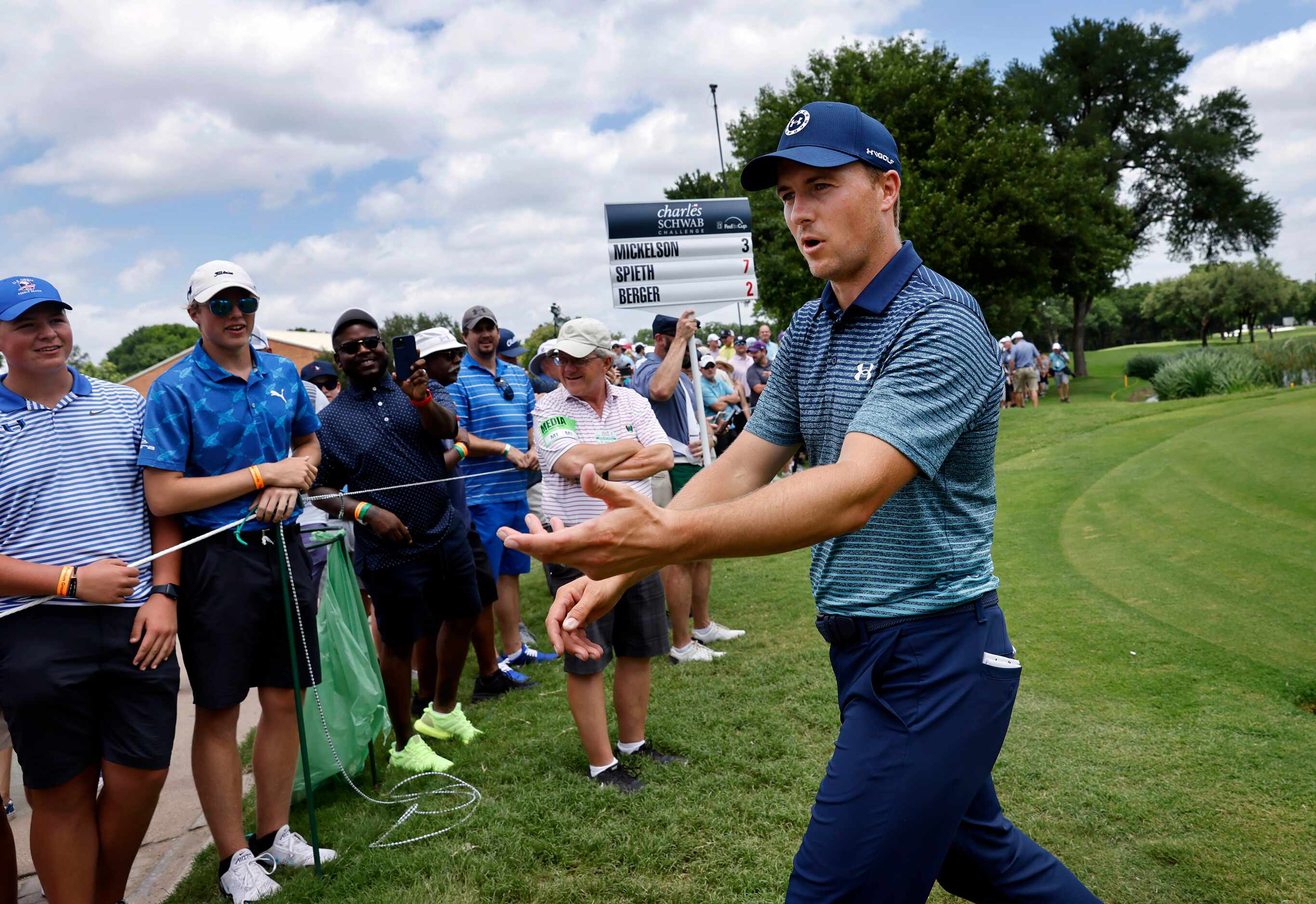Professional golfer Jordan Spieth reacts to fans after he finished round one with a 7-under,...