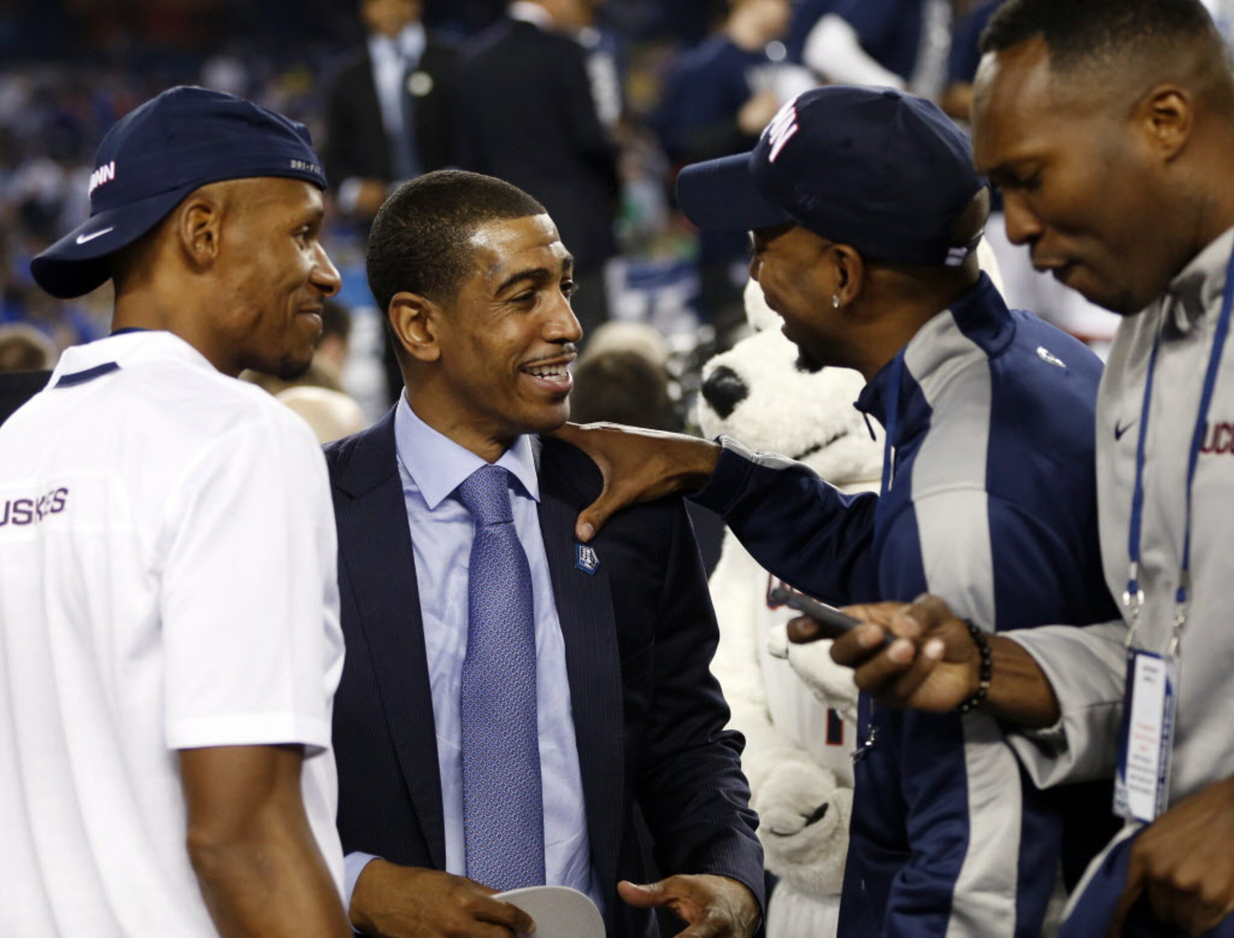 Connecticut Huskies head coach Kevin Ollie celebrates with other team members following the...