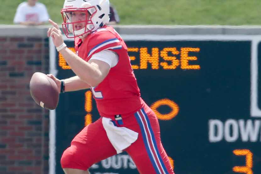 SMU Mustangs quarterback Rafe Peavey directs his receiver as he rolls out looking to pass...