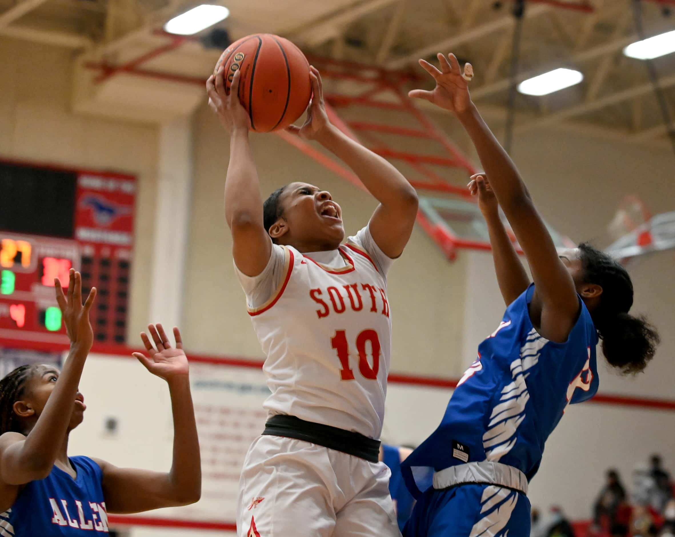 South Grand Prairie’s Victoria Dixon (10) grabs a rebound between Allen’s Alicia Mills and...