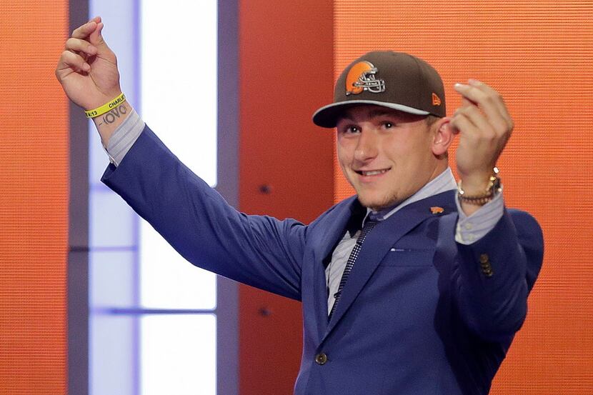 Texas A&M quarterback Johnny Manziel reacts after being selected by the Cleveland Browns as...