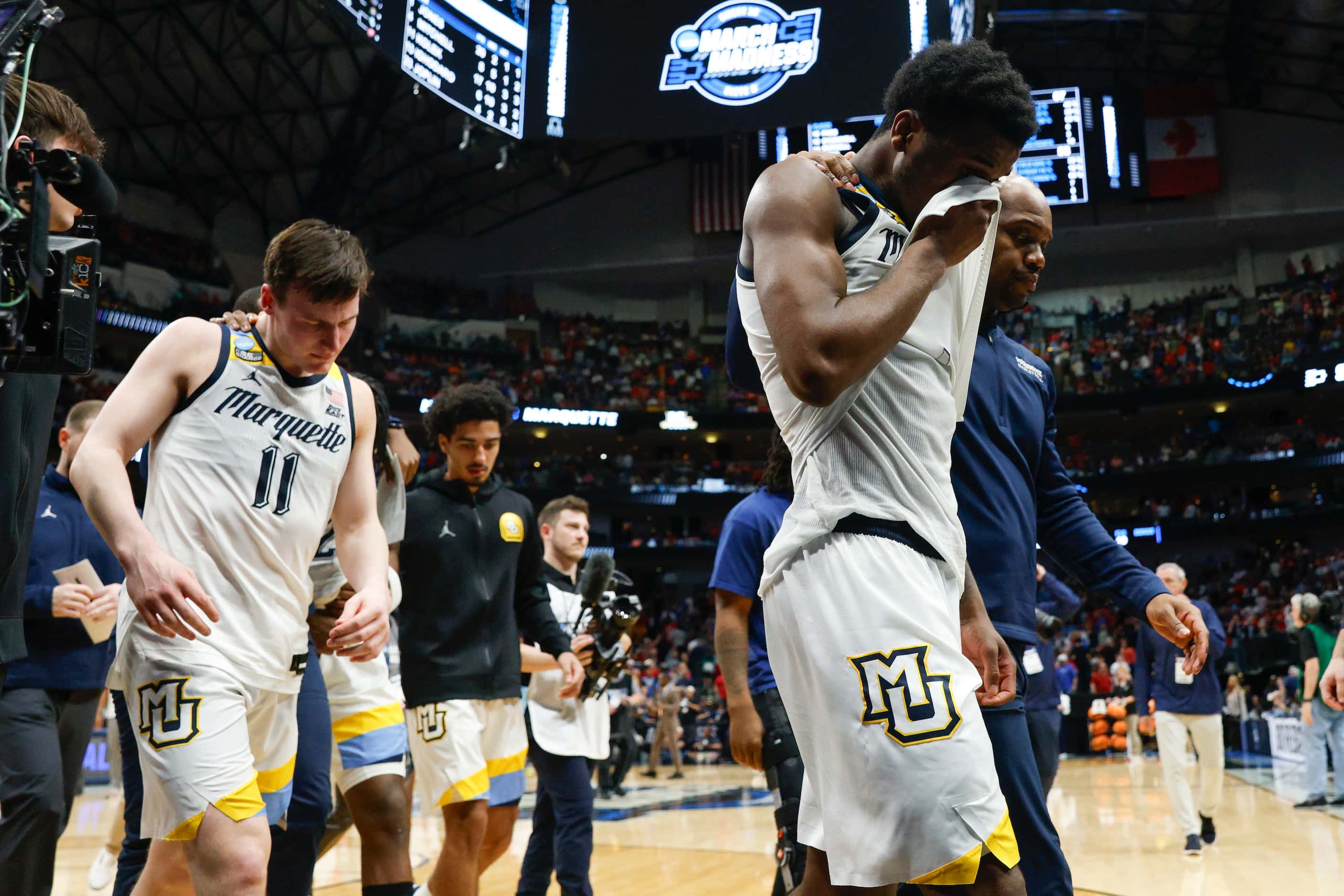 Marquette players are comforted by coaches after losing an NCAA Men’s Sweet 16 basketball...