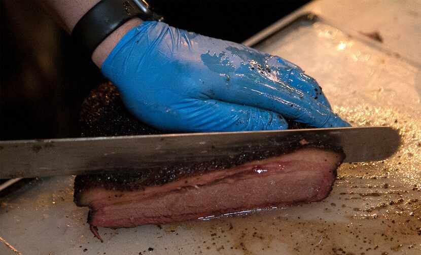 Brandon Mohon slices up brisket he cooked for tacos offered at Las Almas Rotas in Dallas on...