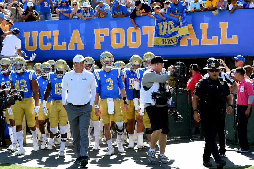 PASADENA, CA - OCTOBER 21:  Head coach Jim Mora of the UCLA Bruins leads his team on to the...