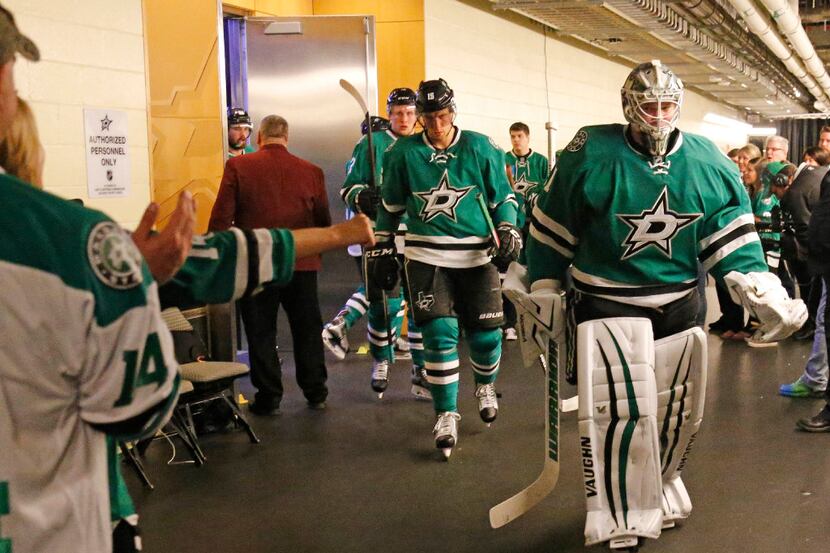 Dallas Stars goalie Antti Niemi (31) an d teammates head out to the ice from theStars'...