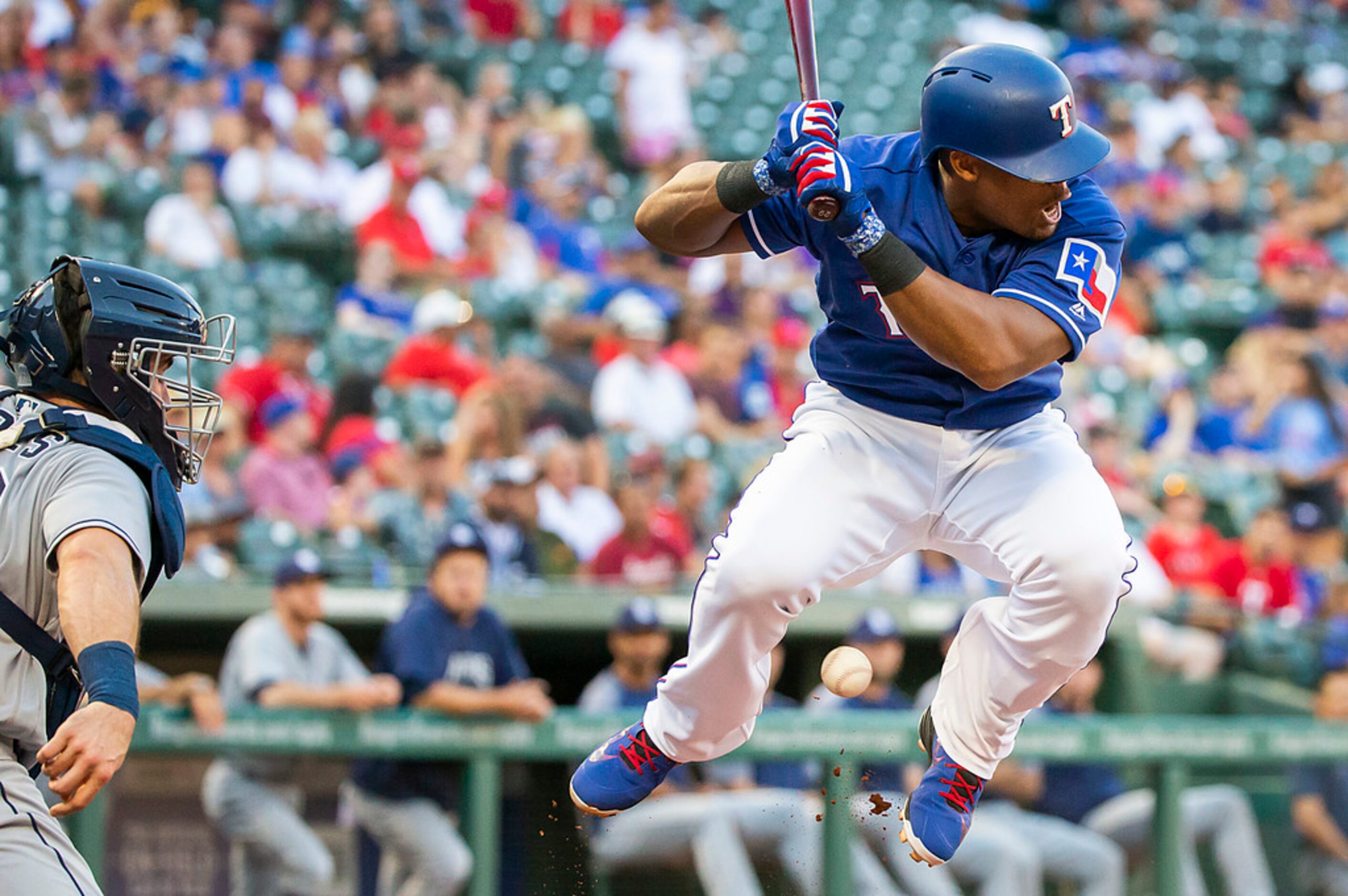 Texas Rangers designated hitter Adrian Beltre tries to leap out of the way but is hit in the...