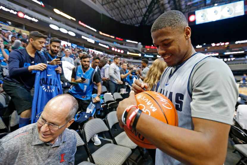 Mavericks guard Dennis Smith Jr. signs autographs for fans after the open practice at...