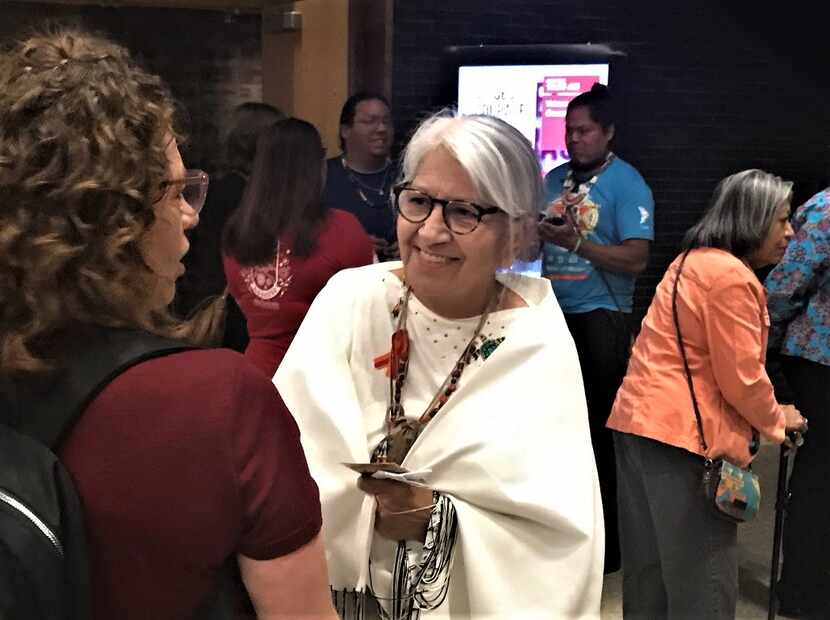 Dora Brought Plenty, an American Indian artist from Dallas, speaks to audience member...