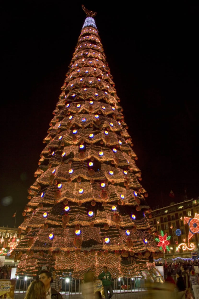 A 50-foot-tall artificial Christmas tree decorated with hundreds of round, red and black...