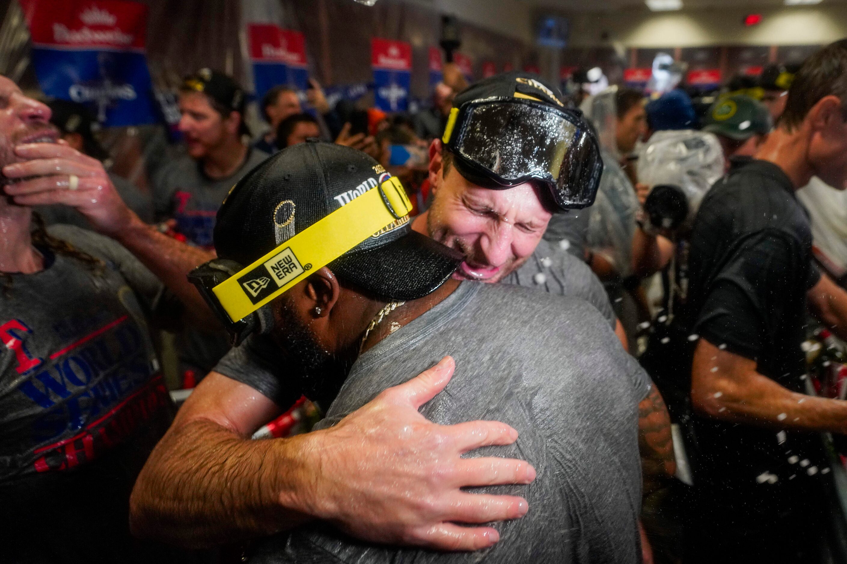 Texas Rangers pitcher Max Scherzer hugs right fielder Adolis Garcia as Rangers players...