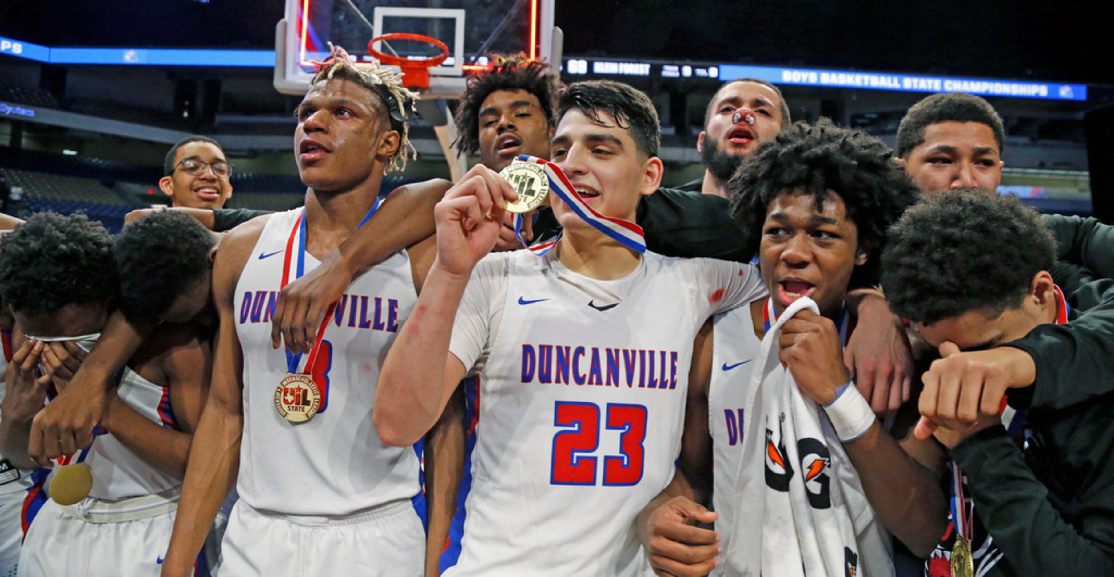 Duncanville players celebrate their 69-73 win against Klein Forest in a UIL boys basketball...