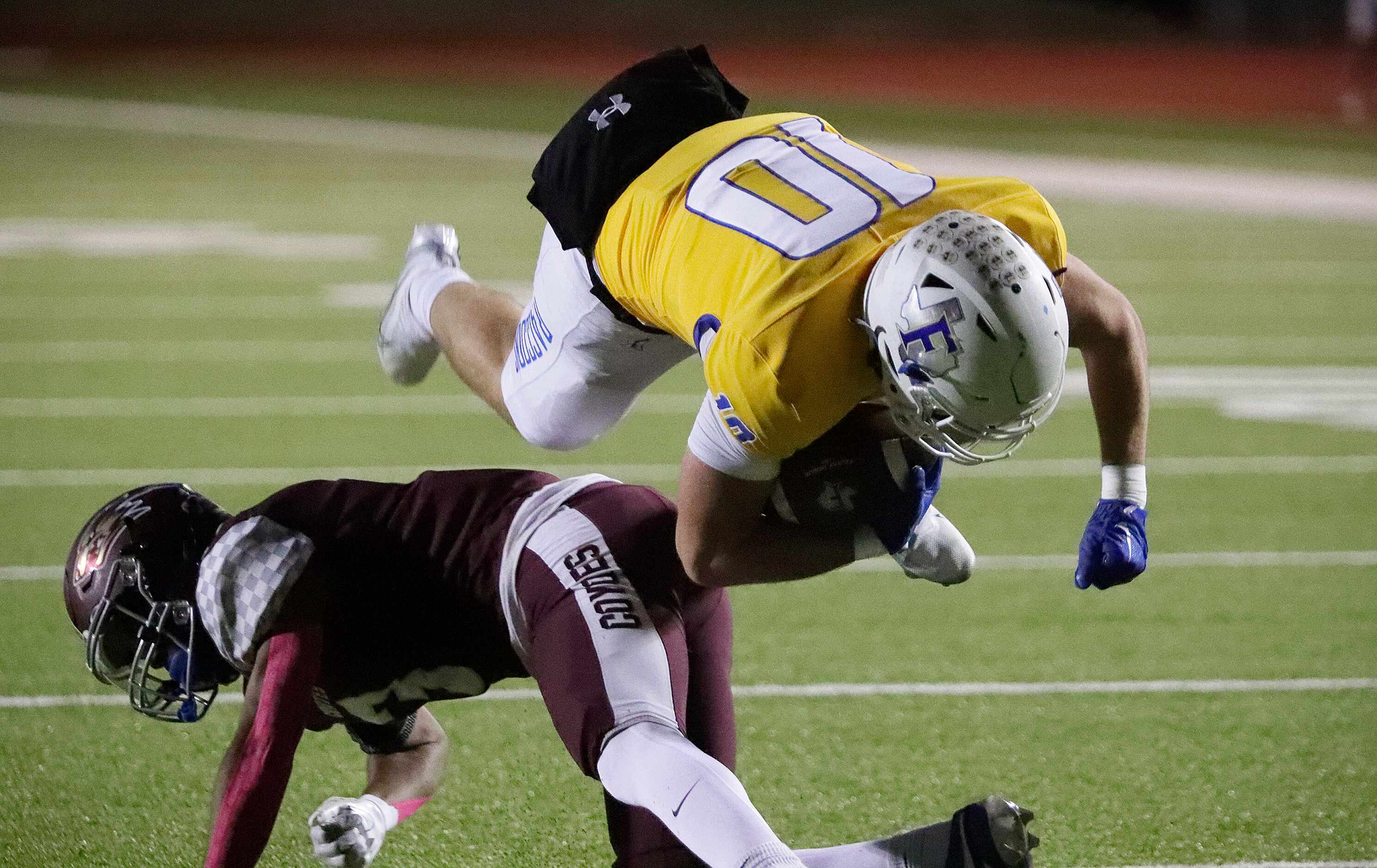 Frisco High School running back Reed Engleman (10) is upended by Frisco Heritage High School...