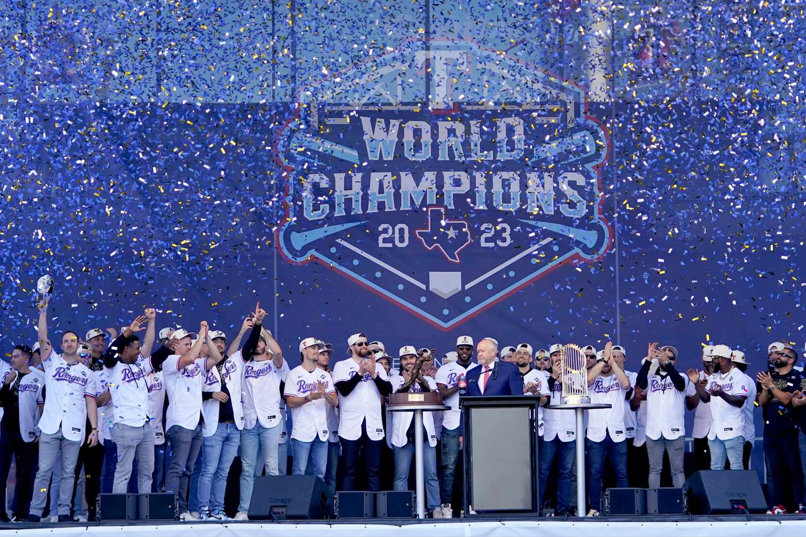 The Texas Rangers team and staff acknowledge cheers from fans during a World Series baseball...