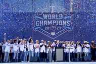 The Texas Rangers team and staff acknowledge cheers from fans during a World Series baseball...