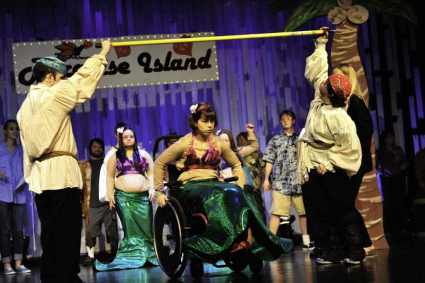 Nancy Appleman, performing as a mermaid, goes under the limbo stick during a dress rehearsal...