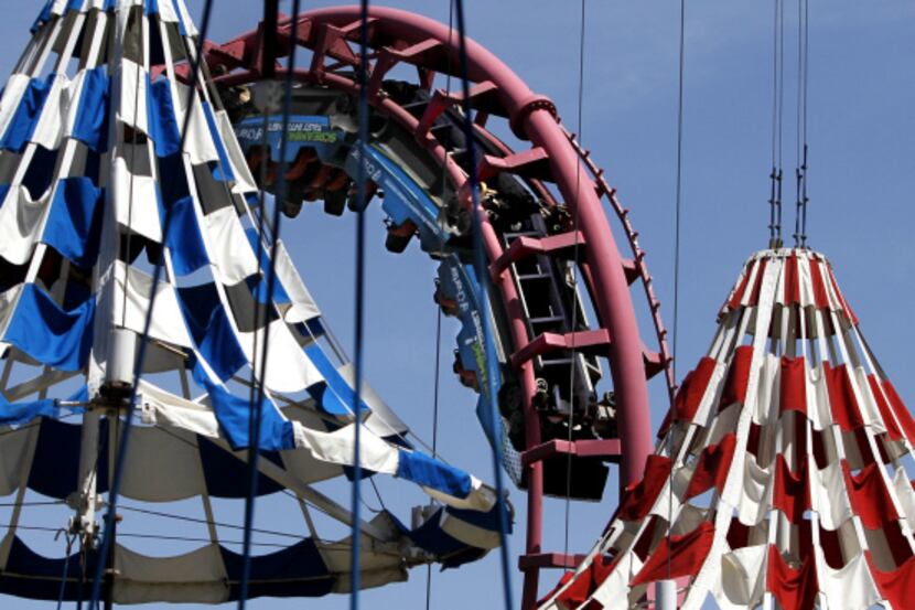 Patrons ride the Flashback at Six Flags Over Texas in Arlington. The Texas Chute Out,...