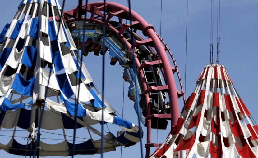 Patrons ride the Flashback at Six Flags Over Texas in Arlington. The Texas Chute Out,...