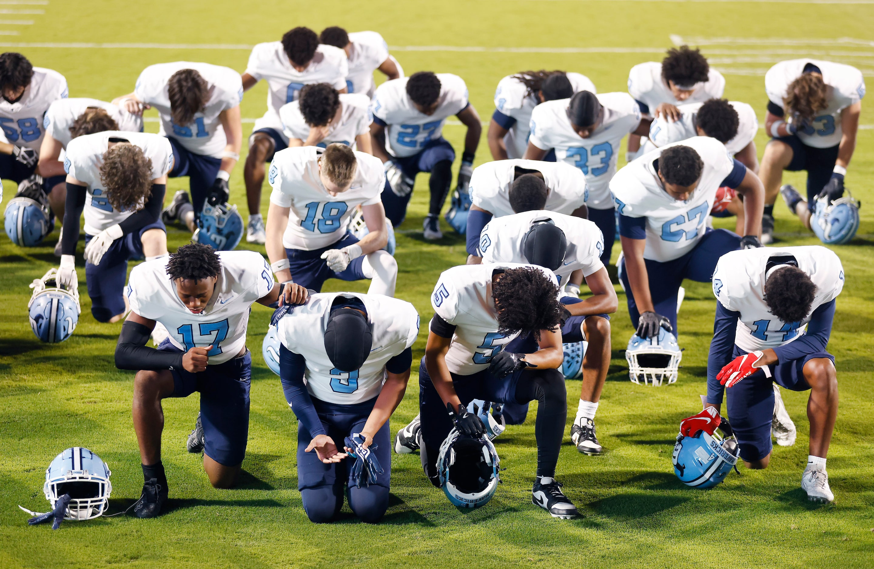 The Frisco Emerson football team kneels in prayer before facing Frisco Independence at...