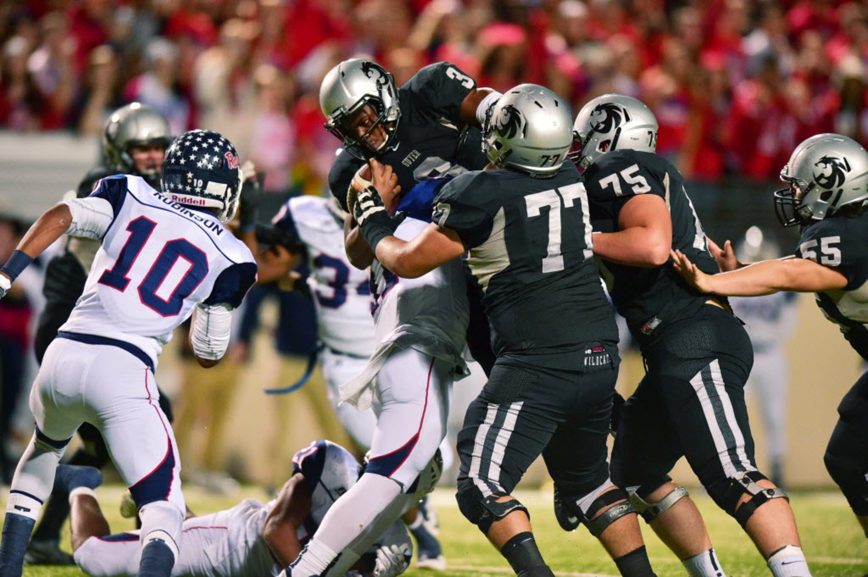 Guyer junior quarterback Shawn Robinson (3) goes up and over for a gain against Ryan,...