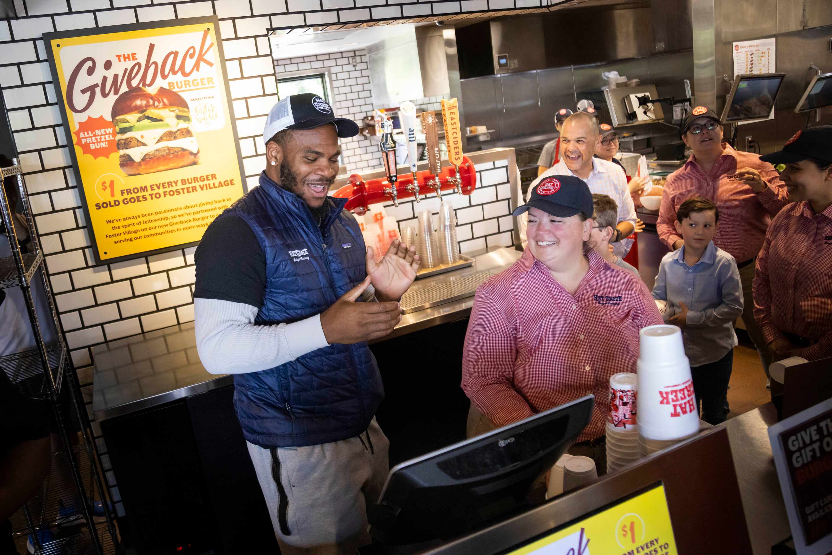 Dallas Cowboys linebacker Micah Parsons laughs while getting ready to use the cash register...