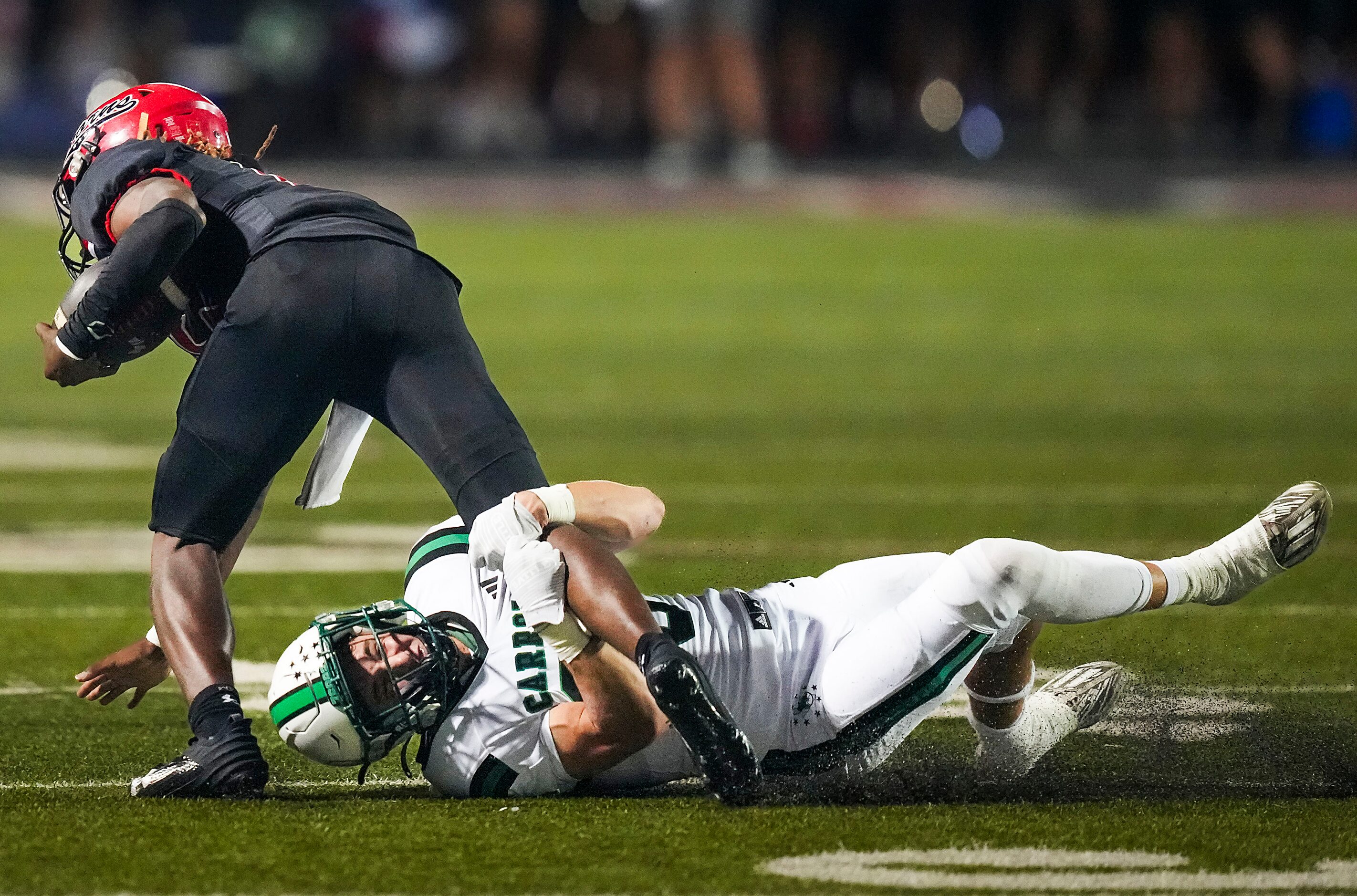 Southlake Carroll defensive back Sam Fuller (25) brings down Cedar Hill quarterback Jaylon...