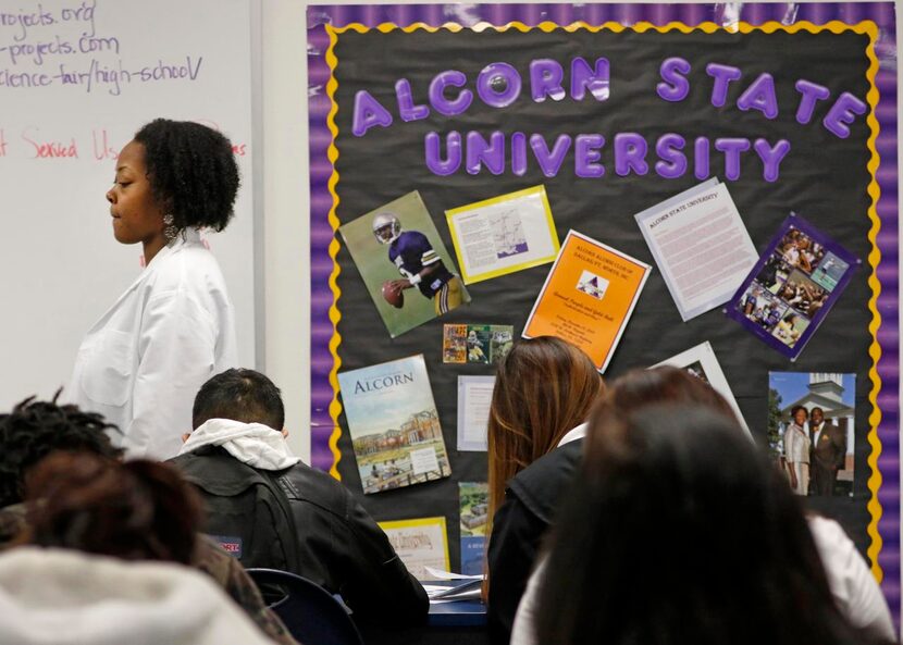 
Regina Parhan, science teacher at Dallas Can Academy, walks past a wall decorated for...