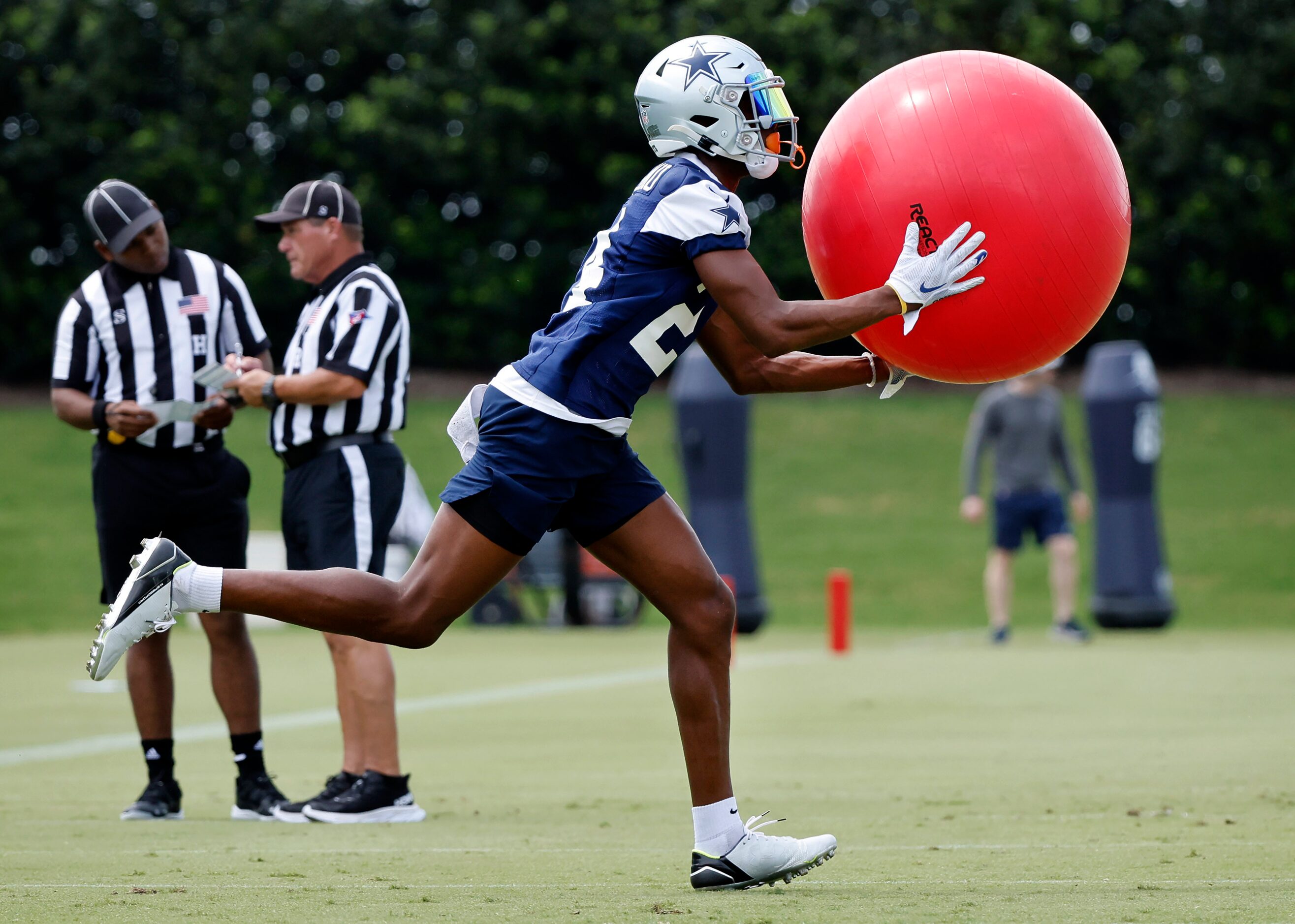 Dallas Cowboys safety Israel Mukuamu (24) scoops up an exercise ball during a training camp...