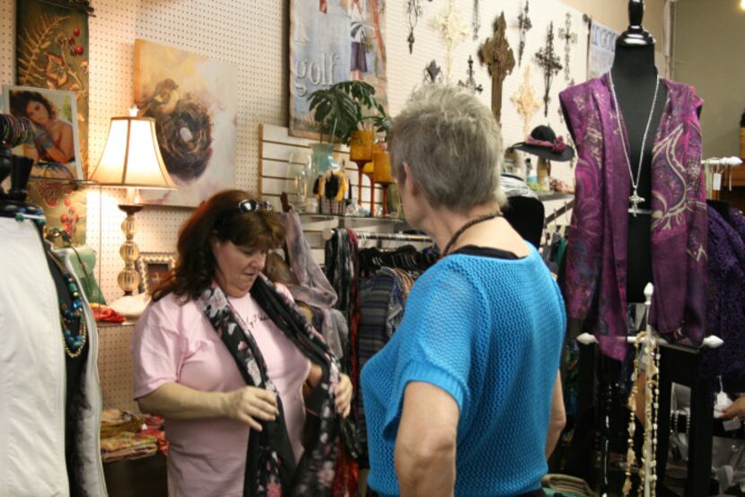Ten of Arts co-owner Lynn Hosid helps Carrollton resident Patti Laurents during a busy...