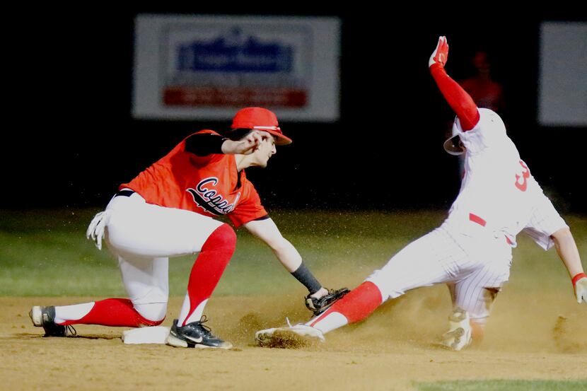 Coppell High School second baseman Tanner Sever (14) tags out Marcus High School center...