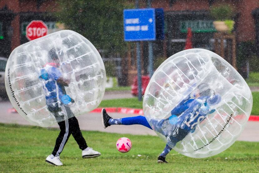 Fans play bubble soccer in the rain outside Toyota Stadium in Frisco before the Gold Cup...