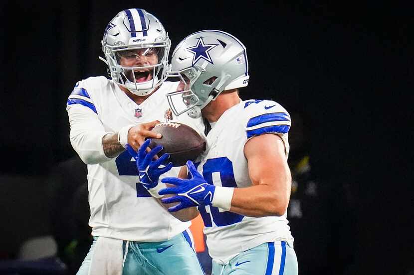 Dallas Cowboys quarterback Dak Prescott (4) gives the ball to running back Hunter Luepke...